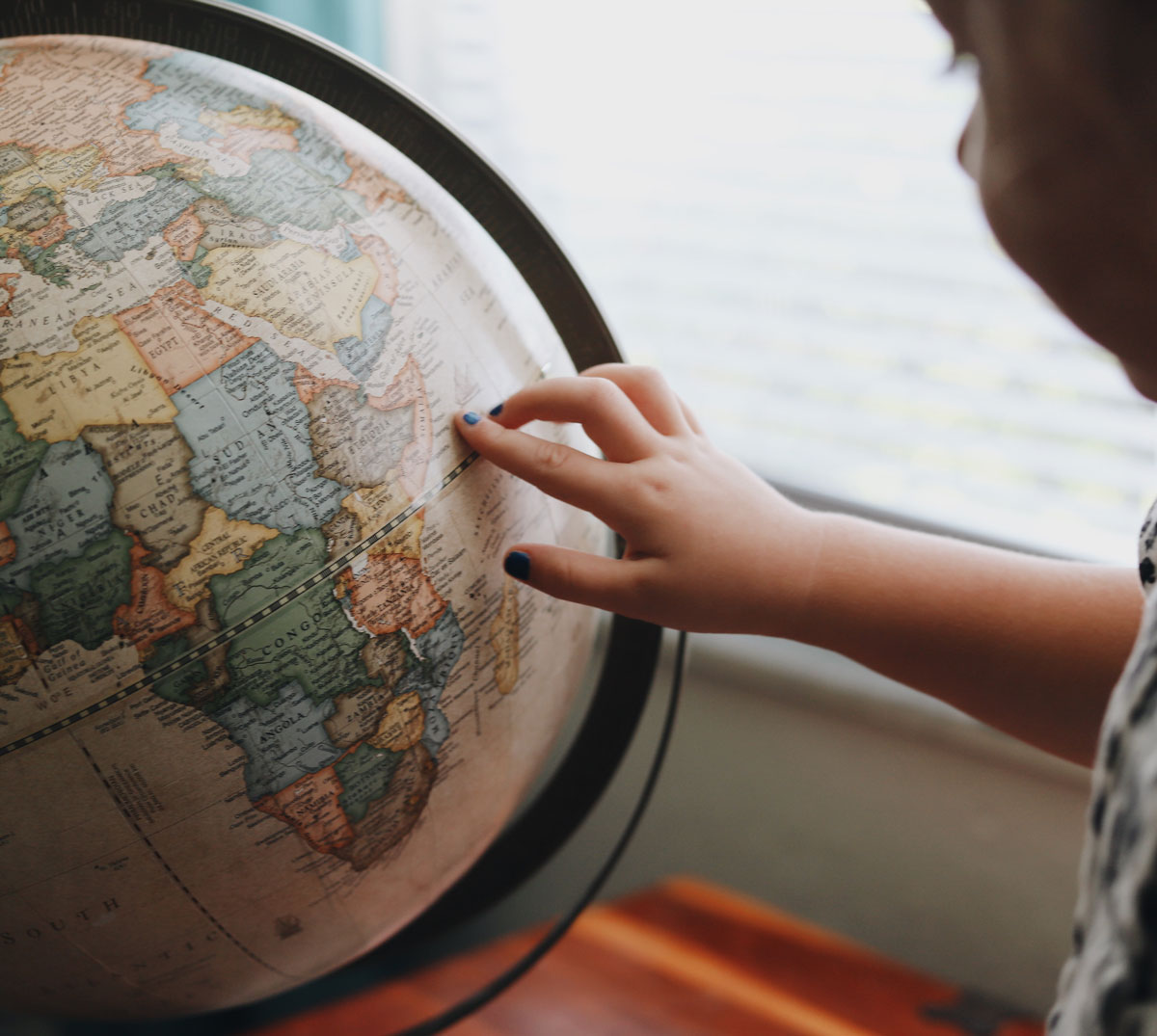 Child spinning world globe